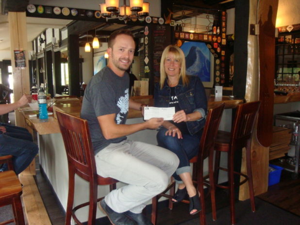 Robin from the White Whale presenting a cheque for $750.00 to Ocean from YANA  