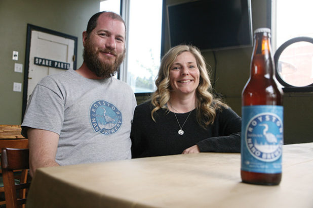 Brad Harris and his wife Denise display a bottle of Royston Nano Brewery beer at Gladstone Brewing Company, the site of an upcoming fundraiser for YANA featuring Harris's beer. PHOTO BY ERIN HALUSCHAK